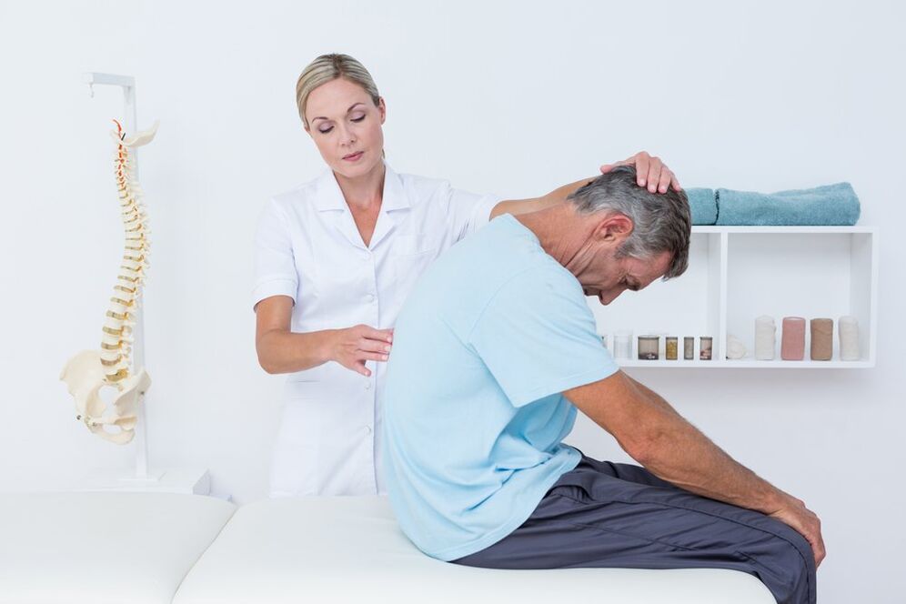 Der Arzt untersucht den Rücken mit Osteochondrose
