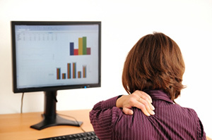 Zervikale Osteochondrose in einer Frau, die am Computer sitzt